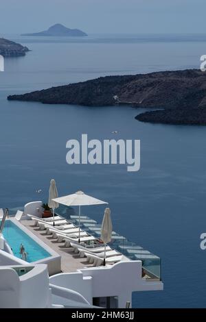 Santorini, Grecia - 7 maggio 2021 : una piscina con lettini da mare in un hotel di lusso che si affaccia sul mar egeo in Santorini Grecia Foto Stock