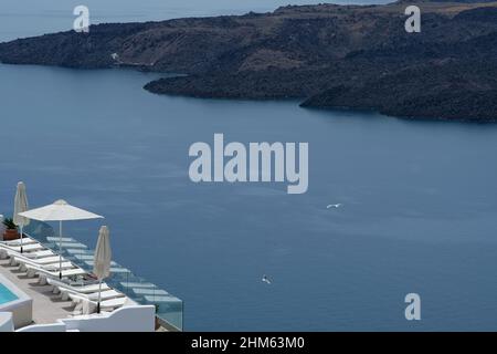 Santorini, Grecia - 7 maggio 2021 : una piscina con lettini da mare in un hotel di lusso che si affaccia sul mar egeo in Santorini Grecia Foto Stock