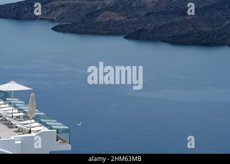 Santorini, Grecia - 7 maggio 2021 : una piscina con lettini da mare in un hotel di lusso che si affaccia sul mar egeo in Santorini Grecia Foto Stock