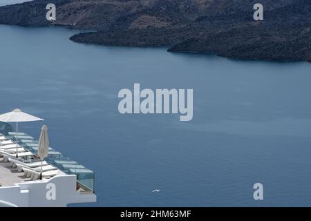 Santorini, Grecia - 7 maggio 2021 : una piscina con lettini da mare in un hotel di lusso che si affaccia sul mar egeo in Santorini Grecia Foto Stock