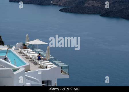 Santorini, Grecia - 7 maggio 2021 : una piscina con lettini da mare in un hotel di lusso che si affaccia sul mar egeo in Santorini Grecia Foto Stock