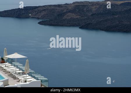 Santorini, Grecia - 7 maggio 2021 : una piscina con lettini da mare in un hotel di lusso che si affaccia sul mar egeo in Santorini Grecia Foto Stock