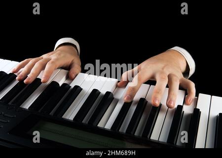 le mani del pianista in nero sui tasti del pianoforte si avvicinano Foto Stock