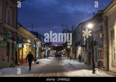 Foto di persone che camminano sotto la neve in inverno nel centro della città di Pancevo, Serbia. Pancevo è una città e il centro amministrativo del sud Foto Stock