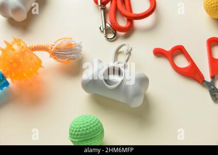 Dispenser con sacchetti per rifiuti animali domestici e accessori su sfondo colorato, primo piano Foto Stock