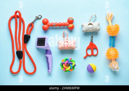 Set di diversi accessori per la cura degli animali domestici con sacchetti per rifiuti su sfondo colorato Foto Stock
