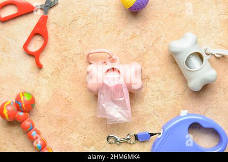 Sacchetti per rifiuti in PET, guinzaglio, tagliaunghie e giocattolo su sfondo colorato, primo piano Foto Stock