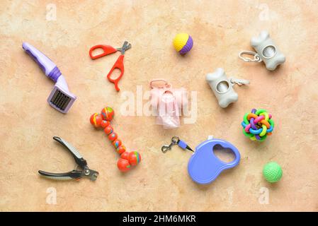 Diversi accessori per la cura degli animali domestici e dispenser con sacchetti per rifiuti animali domestici su sfondo colorato Foto Stock