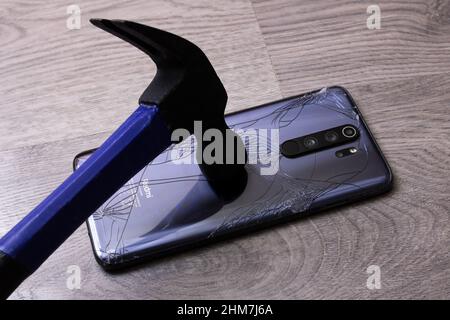 Bielorussia, Novopolotsk - 19 januay, 2022: Il martello rompe xiaomi phone cover close up Foto Stock