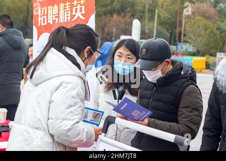 NANTONG, CINA - 8 FEBBRAIO 2022 - i cercatori di lavoro cercano informazioni ad una fiera di lavoro a Nantong, nella provincia di Jiangsu della Cina orientale, il 8 febbraio 2022. Foto Stock