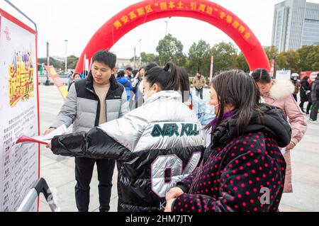 NANTONG, CINA - 8 FEBBRAIO 2022 - i cercatori di lavoro cercano informazioni ad una fiera di lavoro a Nantong, nella provincia di Jiangsu della Cina orientale, il 8 febbraio 2022. Foto Stock