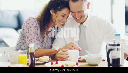 L'amore accende la giornata. Shot di una coppia affettuosa di mezza età che ha fatto colazione insieme la mattina a casa. Foto Stock