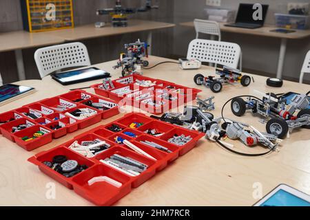 Immagine di sfondo della costruzione di robot set di parti in contenitori sul tavolo in robotica e classe di ingegneria presso la scuola moderna, spazio copia Foto Stock