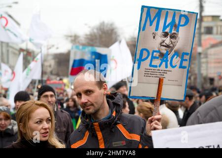 Mosca, Russia. 15th marzo 2014 Un uomo ha una bandiera anti-guerra con ritratto di Mahatma Gandhi e le iscrizioni russe e inglesi 'Peace' durante la marcia di pace da parte dell'anello del viale della Mosca centrale a sostegno del popolo ucraino e contro le azioni militari in Ucraina Foto Stock