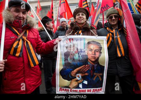 Mosca, Russia. 21st febbraio, 2015 persone hanno striscioni e bandiere durante la marcia di attivisti del movimento 'Anti-Maidan' (sostenitori Pro-Cremlino) nel giorno del primo anniversario degli eventi sanguinosi sulla Maidan in Ucraina nel centro di Mosca, Russia. Il banner recita: 'Zio Sam non è mio zio' Foto Stock