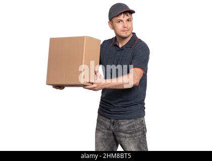 Addetto alla consegna che dà scatola di cartone. Ritratto di corriere sorridente felice in cap tenuta pacco scatola isolato su sfondo bianco. Foto Stock