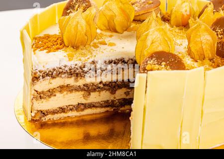 Primo piano di torta stratificata con crema di mascarpone decorata con mirtilli d'oro Foto Stock
