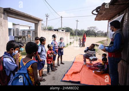 Nabin Nagar, Bengala Occidentale, India. 7th Feb 2022. Il governo dello Stato del Bengala occidentale ha lanciato "'˜Paray Shikshalaya' a decorrere dal 7th febbraio, Uno sforzo di scolarizzazione basato sulla comunità nei quartieri che mira gli studenti primari a mirare al programma è quello di svezzare una grande sezione di studenti che ha abbandonato il sistema di istruzione formale negli ultimi due anni a causa della chiusura delle scuole, a causa di Covid-19. Una classe preprimaria della scuola elementare di confine India-Bangladesh è stata portata su una strada vuota accanto alla recinzione a Nabin Nagar, ci sono occasionalmente animali domestici che entrano. (Credito Foto Stock