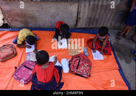 Nabin Nagar, Bengala Occidentale, India. 7th Feb 2022. Il governo dello Stato del Bengala occidentale ha lanciato "'˜Paray Shikshalaya' a decorrere dal 7th febbraio, Uno sforzo di scolarizzazione basato sulla comunità nei quartieri che mira gli studenti primari a mirare al programma è quello di svezzare una grande sezione di studenti che ha abbandonato il sistema di istruzione formale negli ultimi due anni a causa della chiusura delle scuole, a causa di Covid-19. Una classe preprimaria della scuola elementare di confine India-Bangladesh è stata portata su una strada vuota accanto alla recinzione a Nabin Nagar, ci sono occasionalmente animali domestici che entrano. (Credito Foto Stock