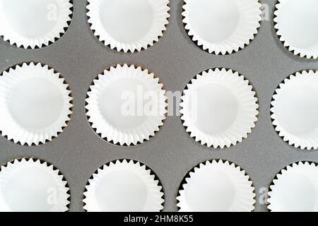 Foderare la teglia per cupcake con i fodere per preparare i cupcake di s'mers. Foto Stock