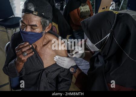 Makassar, Sulawesi meridionale, Indonesia. 8th Feb 2022. Gli operatori sanitari stanno iniettando il vaccino Covid-19 ad un uomo anziano presso l'edificio della scuola elementare di Athira a Makassar City, insieme al numero crescente di casi di Omicron in Indonesia. La vaccinazione per gli anziani viene effettuata per fornire immunità alla variante omicron di Covid-19. (Credit Image: © Herwin Bahar/ZUMA Press Wire) Foto Stock