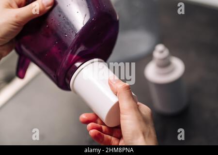 Donna che sostituisce il filtro in una caraffa d'acqua. La mano femmina rimuove una vecchia cartuccia di purificazione dell'acqua del rubinetto da una caraffa. Il processo di sostituzione di un vecchio wat Foto Stock