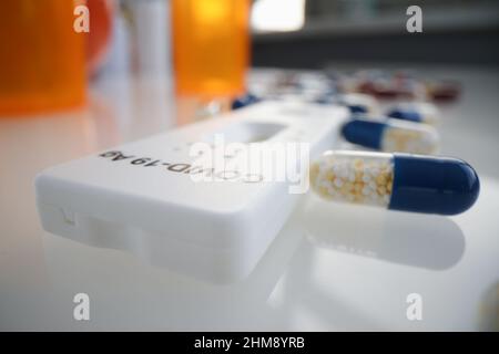 Test espresso per l'antigene del covid 19 che si trova tra molte capsule mediche closeup Foto Stock