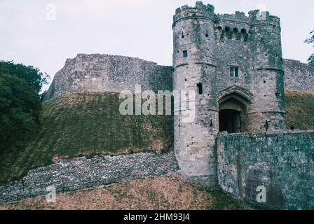 Il castello di Carisbrooke è uno storico castello di motte-and-bailey vicino a Newport, Isola di Wight, Inghilterra. Il sito era occupato in epoca pre-romana, le mura in rovina suggeriscono che vi erano edifici in epoca romana. Gatehouse e ponte. Scansione di archivio da un vetrino. Luglio 1975. Foto Stock