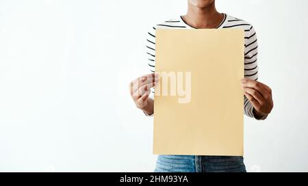 Il giallo è la via da percorrere. Ripresa ritagliata in studio di una donna che tiene un poster giallo su uno sfondo bianco. Foto Stock