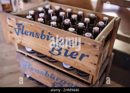 08 febbraio 2022, Schleswig-Holstein, Flensburg: Flachenbiere della fabbrica di birra Flensburg, in una scatola di legno per la linea di imbottigliamento. La birreria ha annunciato gli anni 2021. Foto: Axel Heimken/dpa Foto Stock