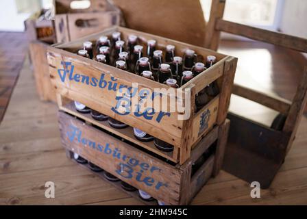 08 febbraio 2022, Schleswig-Holstein, Flensburg: Flachenbiere della fabbrica di birra Flensburg, in una scatola di legno per la linea di imbottigliamento. La birreria ha annunciato gli anni 2021. Foto: Axel Heimken/dpa Foto Stock