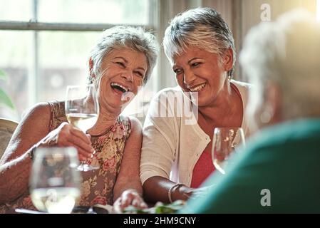 Mi ricordo di quei giorni. Scatto ritagliato di un gruppo di amici anziani che si godono una data pranzo. Foto Stock