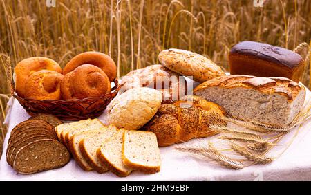 lotto di pane, grano, segale aromatizzato, sulla tavola all'esterno del campo Foto Stock