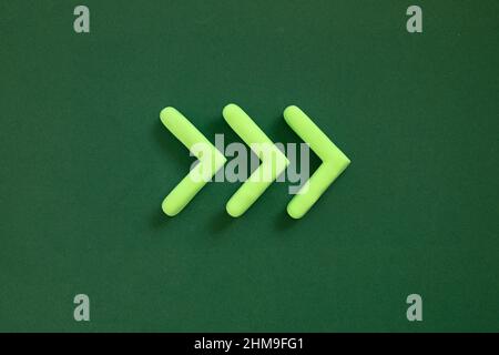 Frecce rivolte verso destra. 3D mockup, segno del puntatore che punta la direzione su sfondo verde. Concetto giusto senso. Foto Stock