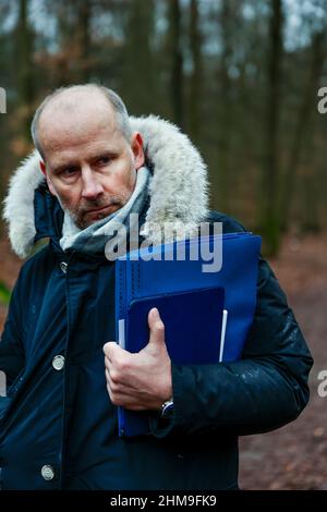 08 febbraio 2022, Berlino: Hendrik Roeke, vedovo e lapide comune, si erge su un sentiero forestale nella foresta di Grunewald durante un'audizione locale presso il tribunale distrettuale di Tiergarten nel processo di un forester del distretto di Berlino. Il forestatore di 42 anni è accusato di omicidio negligente. Nel febbraio 2019, quando ha ispezionato gli alberi di Königsallee a Grunewald, egli ha trascurato il pericolo di caduta dell'acero norvegese di 100 anni. Il 28 ottobre 2019, l'albero cadde sulla macchina di una donna che morì in seguito all'incidente. Foto: Carsten Koall/dpa Foto Stock