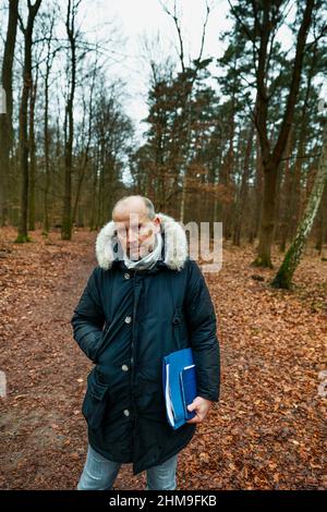 08 febbraio 2022, Berlino: Hendrik Roeke, vedovo e lapide comune, si erge su un sentiero forestale nella foresta di Grunewald durante un'audizione locale presso il tribunale distrettuale di Tiergarten nel processo di un forester del distretto di Berlino. Il forestatore di 42 anni è accusato di omicidio negligente. Nel febbraio 2019, quando ha ispezionato gli alberi di Königsallee a Grunewald, egli ha trascurato il pericolo di caduta dell'acero norvegese di 100 anni. Il 28 ottobre 2019, l'albero cadde sulla macchina di una donna che morì in seguito all'incidente. Foto: Carsten Koall/dpa Foto Stock