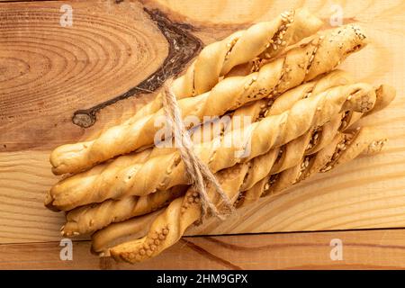 Bastoncini di pane Grissini con semi di sesamo, primo piano, su un tavolo di legno, vista dall'alto. Foto Stock