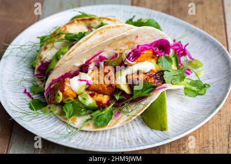 Tacos con salmone, cavolo rosso sottaceto, wasabi mayo e piselli spara Foto Stock