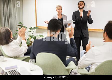 Il team di coaching e i partecipanti al seminario sono felici del successo del seminario e applaudire Foto Stock