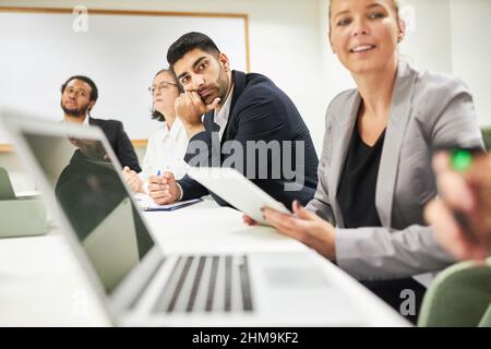 Gruppo di uomini d'affari che imparano insieme in un corso di informatica utilizzando computer portatili in ufficio Foto Stock