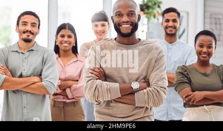 Una squadra di successo è una squadra che lavora bene insieme. Colpo di un gruppo di uomini d'affari che si trovano in un ufficio. Foto Stock