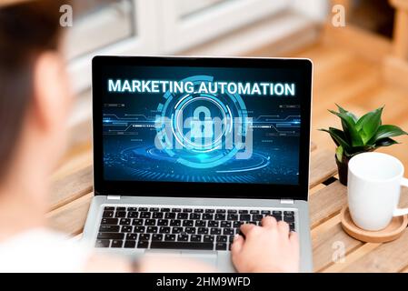 Scrittura visualizzazione testo Marketing Automation. Business Concept Software utilizzato dall'azienda per indirizzare efficacemente il cliente Donna digitando sul laptop accanto Foto Stock