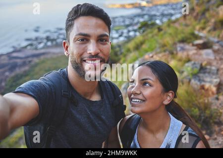 Beh, abbiamo sempre le nostre escursioni. Scatto di una giovane coppia che scatta foto mentre si è fuori in un'escursione in una catena montuosa all'aperto. Foto Stock