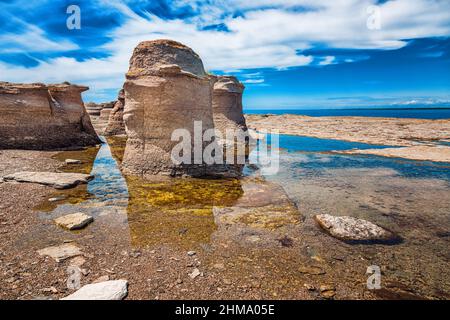 Formazioni rocciose calcaree con cielo estivo nuvoloso sulla costa dell'isola di Île Nue de Mingan, Québec, Canada Foto Stock