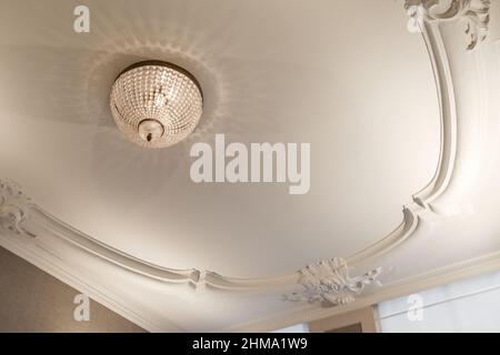 Sala con modanature ornamentali sulle pareti e tavola vuota appesa alla parete Foto Stock