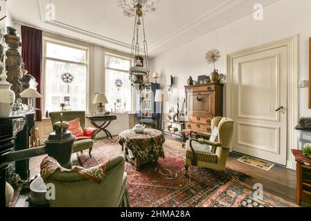 Interno di spaziosa zona salotto con mobili in vecchio stile progettati in stile vintage in casa residenziale Foto Stock