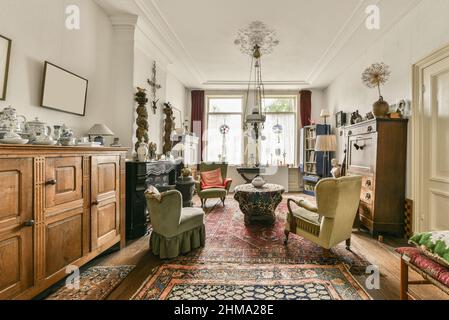 Interno di spaziosa zona salotto con mobili in vecchio stile progettati in stile vintage in casa residenziale Foto Stock