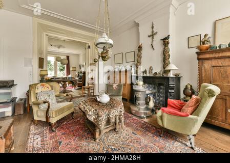 Interno di spaziosa zona salotto con mobili in vecchio stile progettati in stile vintage in casa residenziale Foto Stock