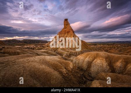 Vista maestosa della formazione rocciosa ruvida della scogliera in terreno semi deserto nel parco nazionale di Bardenas Reales a Navarra in Spagna Foto Stock