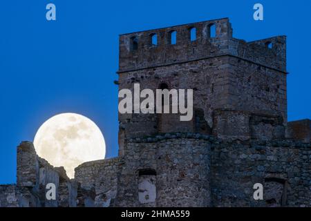 Antico castello di Penafiel con torre situata contro il cielo blu nuvoloso con la luna piena splendente in provincia di Spagna in serata Foto Stock